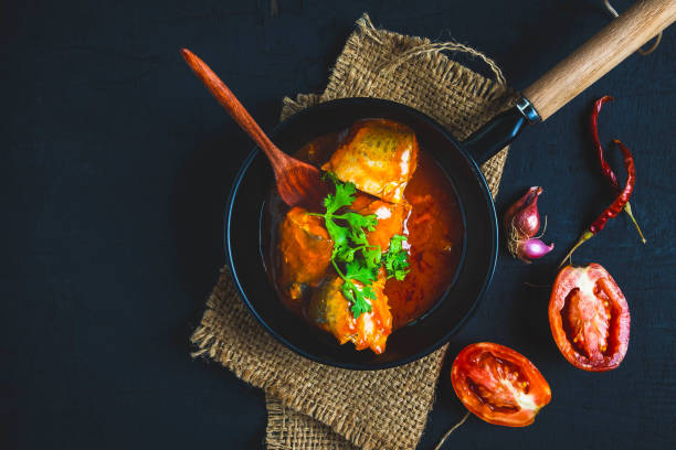 istock Fish with tomato sauce on black background 1173825341