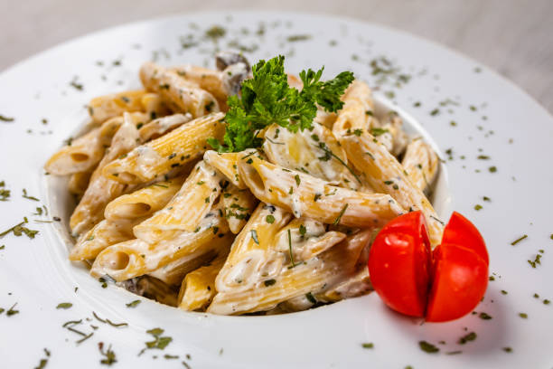 pollo e funghi penne, italienische pasta mit huhn und pilzen - penne rigatoni pasta tomato pasta stock-fotos und bilder