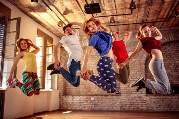 Photo of young modern dancers dancing in the studio. Sport, dancing and urban culture concept