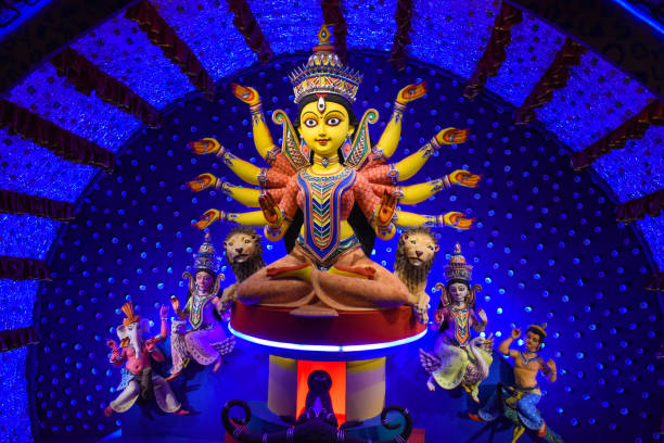 Goddess Durga idol at decorated Durga Puja pandal, shot at colored light, at Kolkata, West Bengal, India. Durga Puja is biggest religious festival of Hinduism and is now celebrated worldwide. stock photo