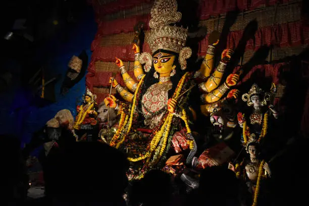 Photo of Goddess Durga idol at decorated Durga Puja pandal, shot at colored light, at Kolkata, West Bengal, India. Durga Puja is biggest religious festival of Hinduism and is now celebrated worldwide.