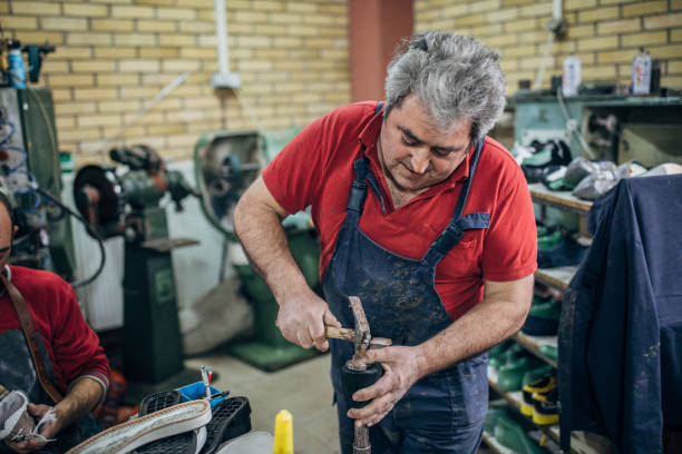 istock Men working in shoe factory 1173832675