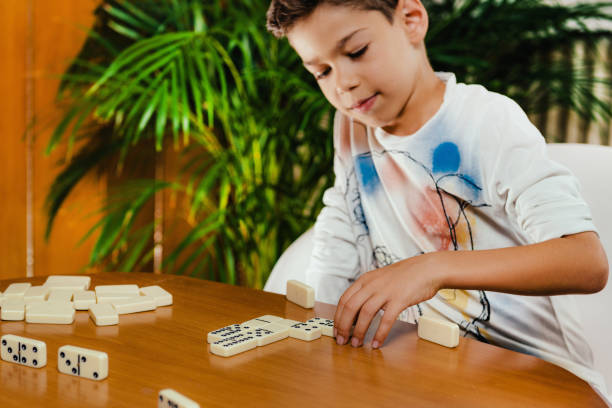 istock School boy playing dominoes 1173833516