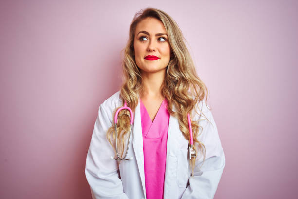istock Young beautiful doctor woman using stethoscope over pink isolated background smiling looking to the side and staring away thinking. 1173835562