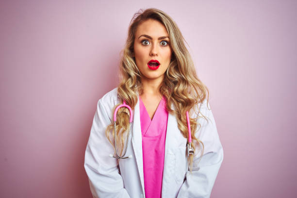 istock Young beautiful doctor woman using stethoscope over pink isolated background afraid and shocked with surprise expression, fear and excited face. 1173835563