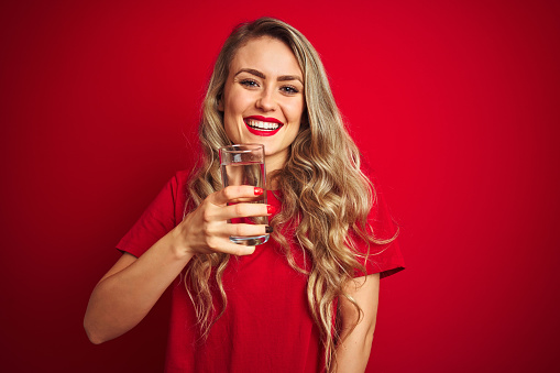 Unrecognizable man pouring water from plastic can into woman mouth