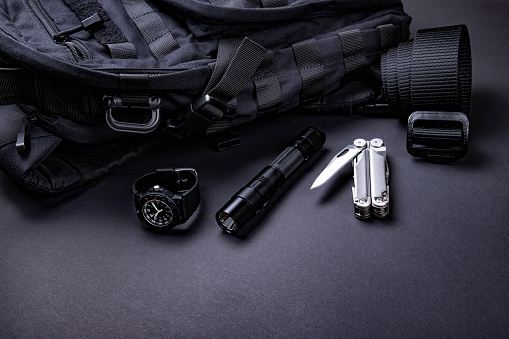 Everyday carry (EDC) items for men in black color - backpack, tactical belt, flashlight,  watch and silver multi tool. Survival set. Minimal concept.
