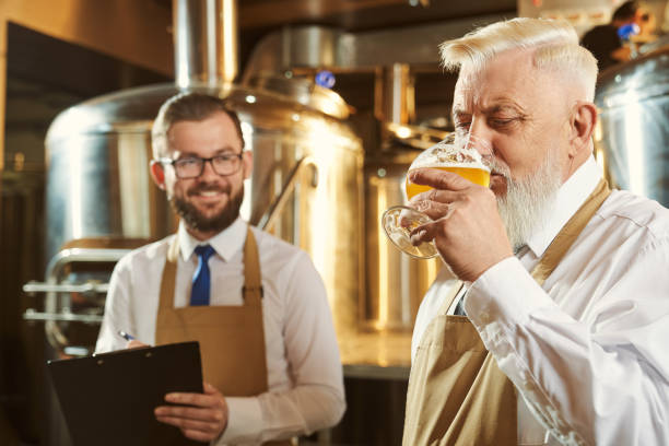 istock Bearded brewer keeping glass of beer and drinking beverage 1173843027