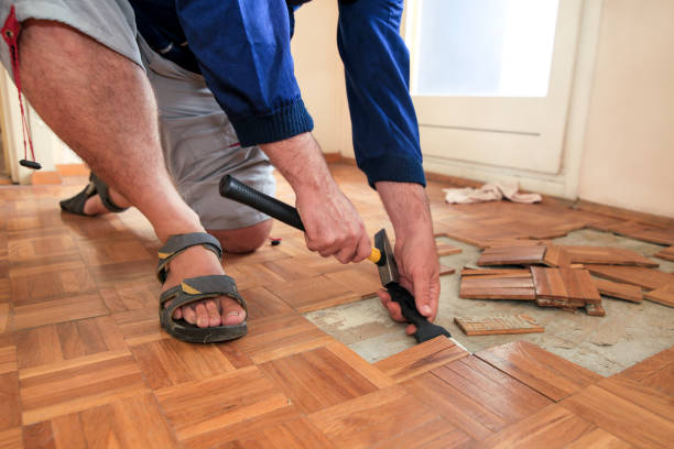 istock Construction worker and constructor is working on renovation of apartment. Handyman is removing old wooden parquet flooring using yellow hammer and scraping tool. Builder dismantles parquet floor. 1173844110