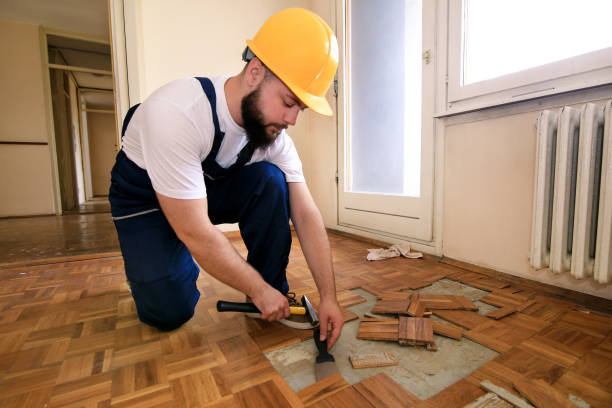 istock Construction worker and constructor is working on renovation of apartment. Handyman is removing old wooden parquet flooring using yellow hammer and scraping tool. Builder dismantles parquet floor. 1173844140
