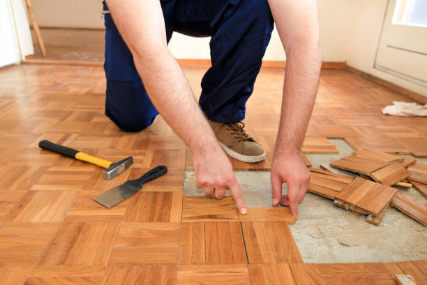 istock Construction worker and constructor is working on renovation of apartment. Handyman is removing old wooden parquet flooring using yellow hammer and scraping tool. Builder dismantles parquet floor. 1173844889