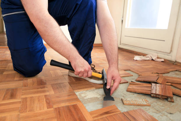 istock Construction worker and constructor is working on renovation of apartment. Handyman is removing old wooden parquet flooring using yellow hammer and scraping tool. Builder dismantles parquet floor. 1173845020