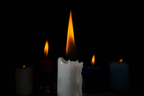 istock Burning candles of different colors in dark 1173845249