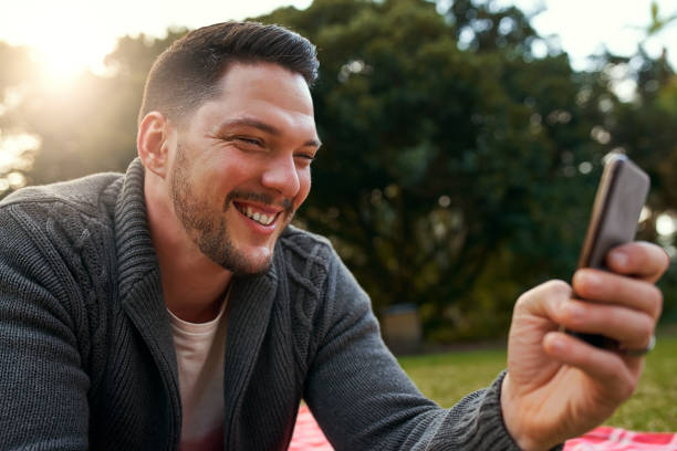 istock Handsome man enjoying in the park taking selfie on mobile phone 1173847606
