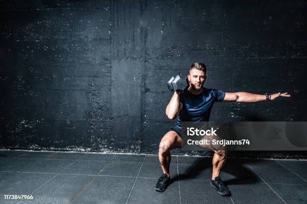 Young Strong Fit Muscular Sweaty Man With Big Muscles Strength Cross Workout Training With Dumbbells Weights In The Gym Dark Image With Shadows Real People Stock Photo - Download Image Now