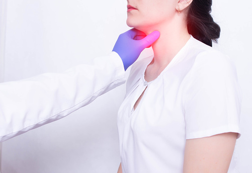 Un médico especialista diagnostica y examina el dolor de garganta de una niña, la presencia de inflamación e hinchazón, faringitis y dolor de garganta, enfermedades photo