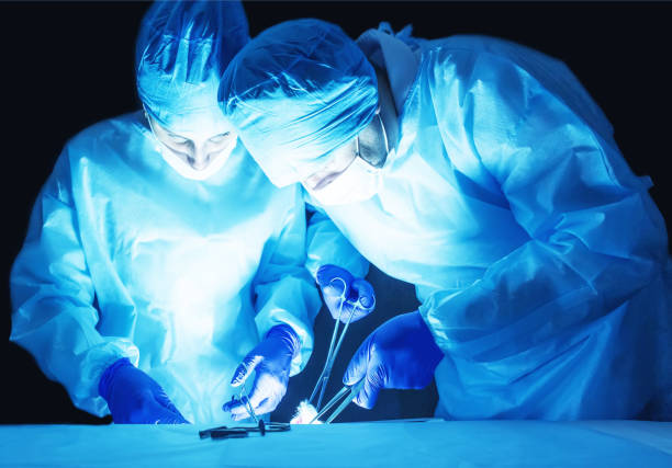 Two surgeons, a man and a woman, perform surgery to remove prostate adenoma and varicocele, fibroadenoma Two surgeons, a man and a woman, perform surgery to remove prostate adenoma and varicocele, fibroadenoma, operating theater hernia photos stock pictures, royalty-free photos & images