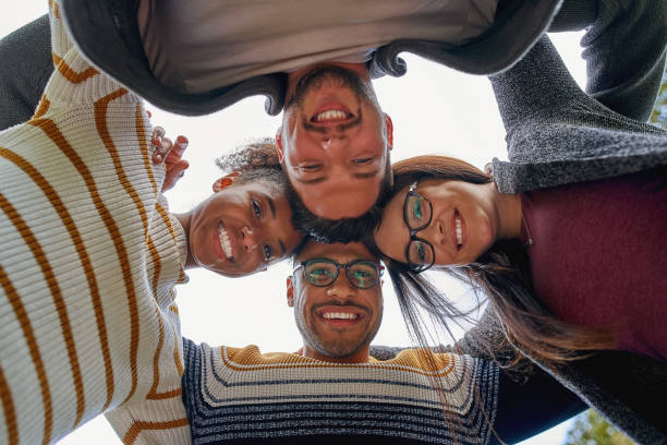 istock Low angle view of happy friendly diverse multi-ethnic friends forming a circle and looking at camera smiling - teamwork 1173853268