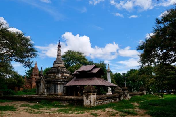 istock group of ancient pagodas under sunny blue sky white clouds. Green trees around. 1173854503