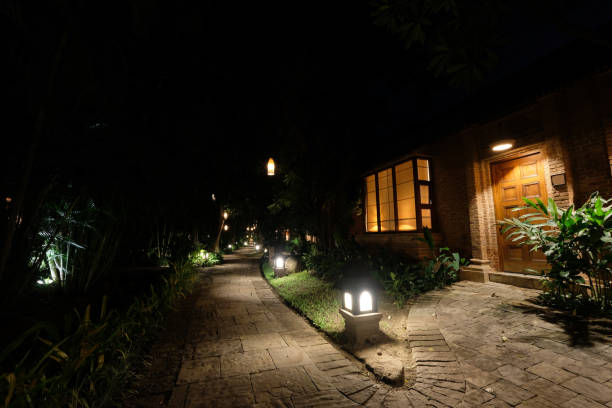 istock house on the tranquil road under dark night sky. Lights on ground. 1173854772
