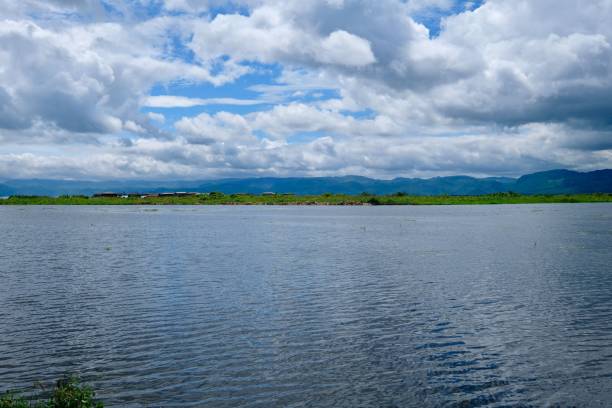 istock flowing Inle Lake under sunny blue sky with white clouds. Wide angle and horizontal. 1173856102