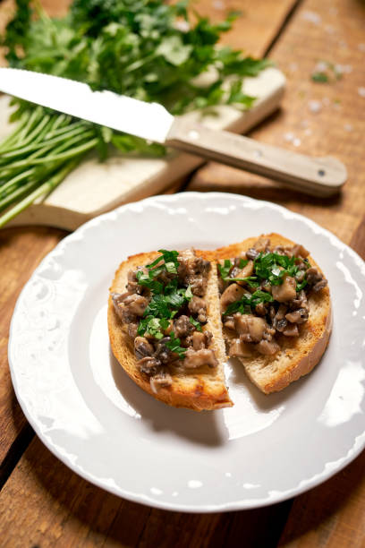 istock Toasts with mushrooms on white plate on wooden kitchen table 1173862310