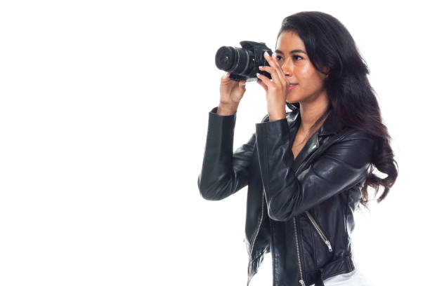 istock Bautiful woman wearing a leather jacket sitting and using a DSLR camera 1173864489