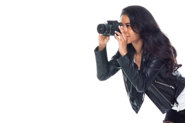 istock Bautiful woman wearing a leather jacket sitting and using a DSLR camera 1173865020