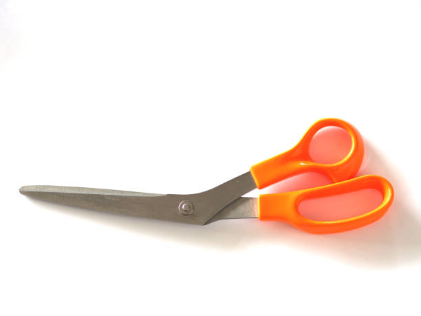 Closeup of a man's hand using scissors against a white background.