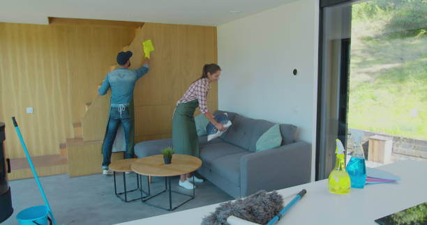 istock Positive smiling professional cleaners doing cleanup in ordinary apartment. 1173878676