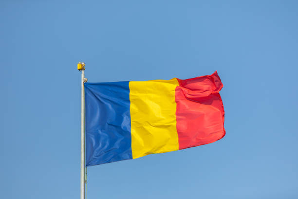 istock Romania flag waving against clean blue sky, close up 1173881417