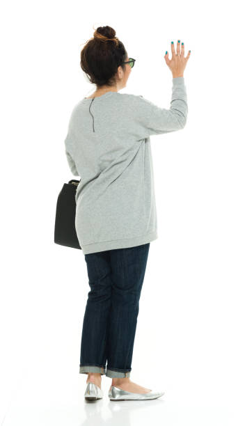 full length / rear view of 30-39 years old adult beautiful puerto rican ethnicity / latin american and hispanic ethnicity female / young women / one young woman only standing in front of white background wearing sweater / jeans / sunglasses - women puerto rican ethnicity smiling cheerful imagens e fotografias de stock