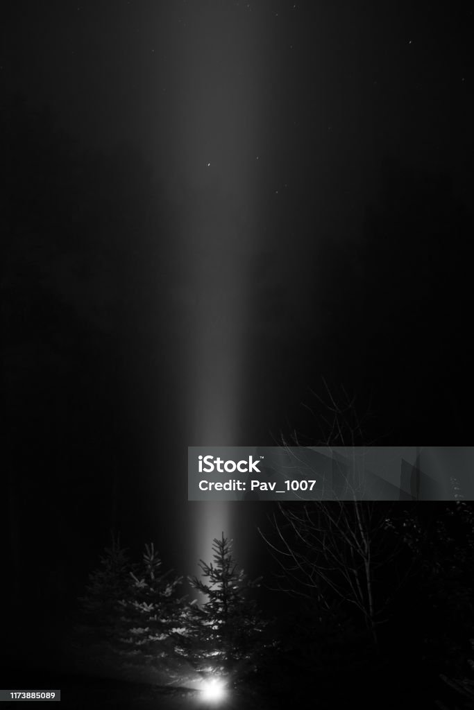 Wiązka światła strzelającego do nieba w mglistą noc - czarno-biała - Zbiór zdjęć royalty-free (Chmura)