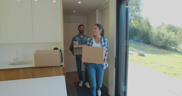 istock Couple Carrying Boxes Into New Home On Moving Day. 1173896717