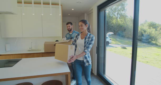 istock Couple Carrying Boxes Into New Home On Moving Day. 1173896744