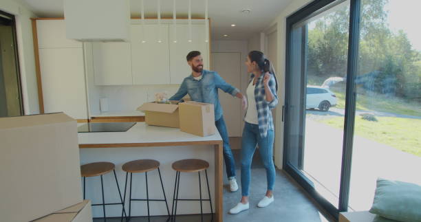 istock Couple Carrying Boxes Into New Home On Moving Day. 1173896795