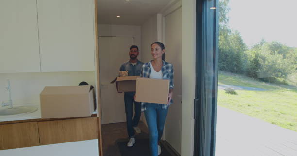 istock Couple Carrying Boxes Into New Home On Moving Day. 1173896877