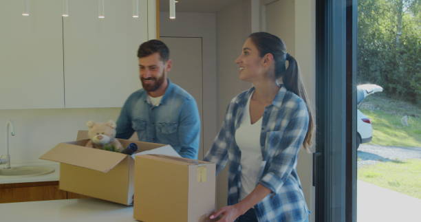 istock Couple Carrying Boxes Into New Home On Moving Day. 1173896998