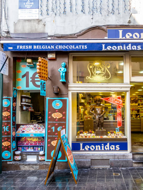 Leonidas chocolate shop in Brussels, Belgium Brussels, Belgium - January 22, 2013: Leonidas chocolate shop at Rue au Beurre with the figure of the famous Manneken Pis, Little Pissing Man, landmark of the City of Brussels manneken pis statue in brussels belgium stock pictures, royalty-free photos & images