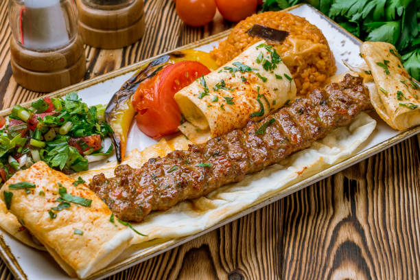 lula kebab spicy with vegetables in Turkish on the board stock photo