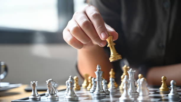 istock Closeup hand confidently colleagues playing chess to develop analysis new strategy and decision plan. 1173908386