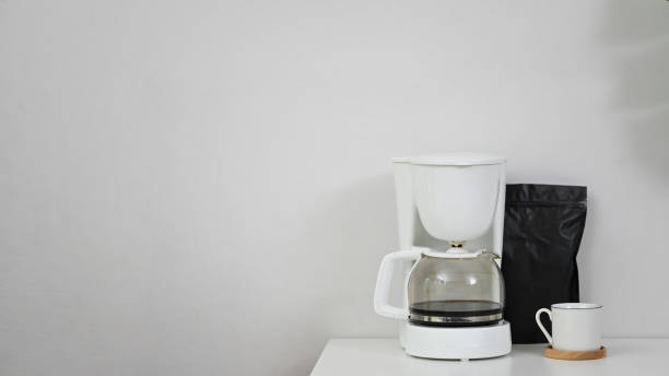 istock Coffee machine, coffee mug and black bag on copy space table. 1173909543
