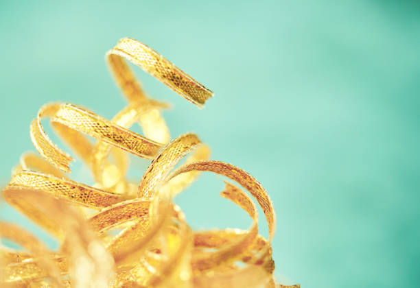 Curly gold ribbon on teal background