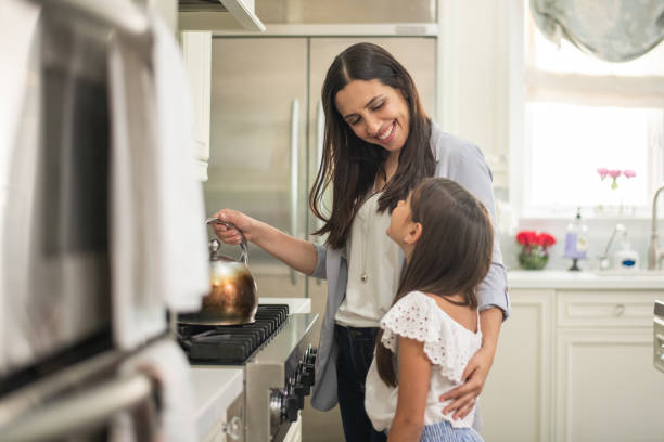 istock Happy mother hugging child daughter in kitchen 1173913639