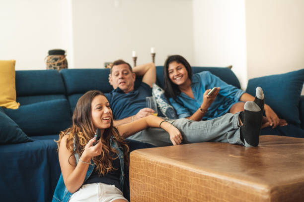 Father and daughters watching tv at home