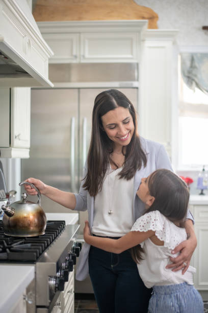 istock Happy mother hugging child daughter in kitchen 1173915261