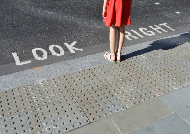 London street crossing Pedestrian standing next to typical road crossing sign in London crossing sign stock pictures, royalty-free photos & images