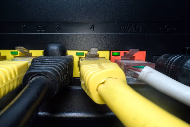 暗い背景にルータパネルに挿入された多色のネットワークケーブル。インターネット接続, 通信産業 - hubcap electric plug network connection plug electricity ストックフォトと画像