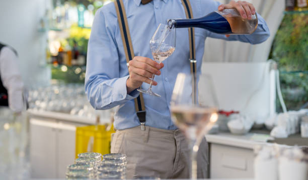 Waiter pouring rose wine Waiter pouring rose wine in glasses at bar, Nikon Z7 cocktail bar busy stock pictures, royalty-free photos & images