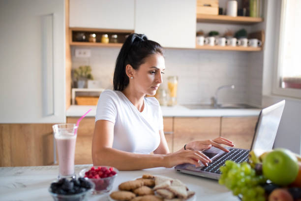 istock Young woman typing an e-mail on laptop at home 1173918250